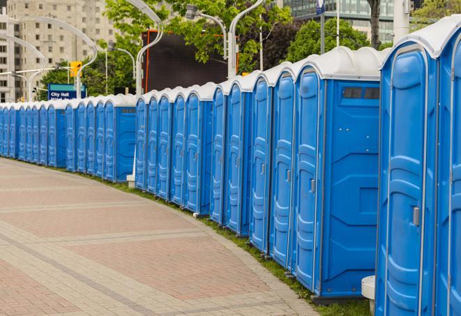 a row of portable restrooms set up for a large athletic event, allowing participants and spectators to easily take care of their needs in Jal